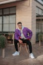 Man in Purple Jacket Sitting on a Chair