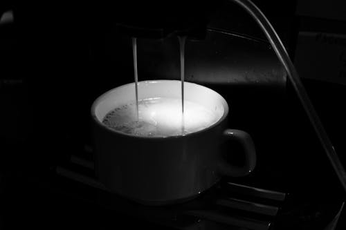 Process of pouring coffee in cup from coffee machine