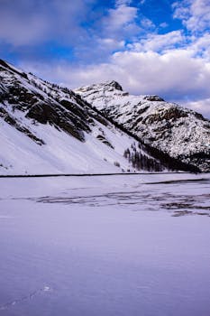 Breathtaking snowy mountains in Livigno, Lombardy with a vibrant blue sky.