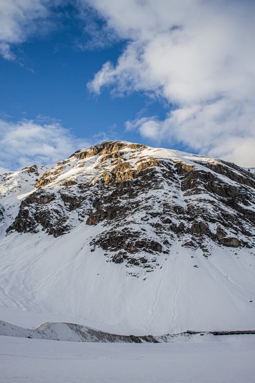 Free A majestic snow-covered mountain under a clear blue sky in Livigno, Italy. Stock Photo