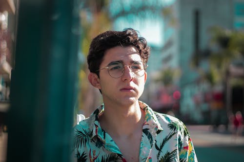 Young Man in Printed Button Down Polo Wearing Eyeglasses while Looking Afar