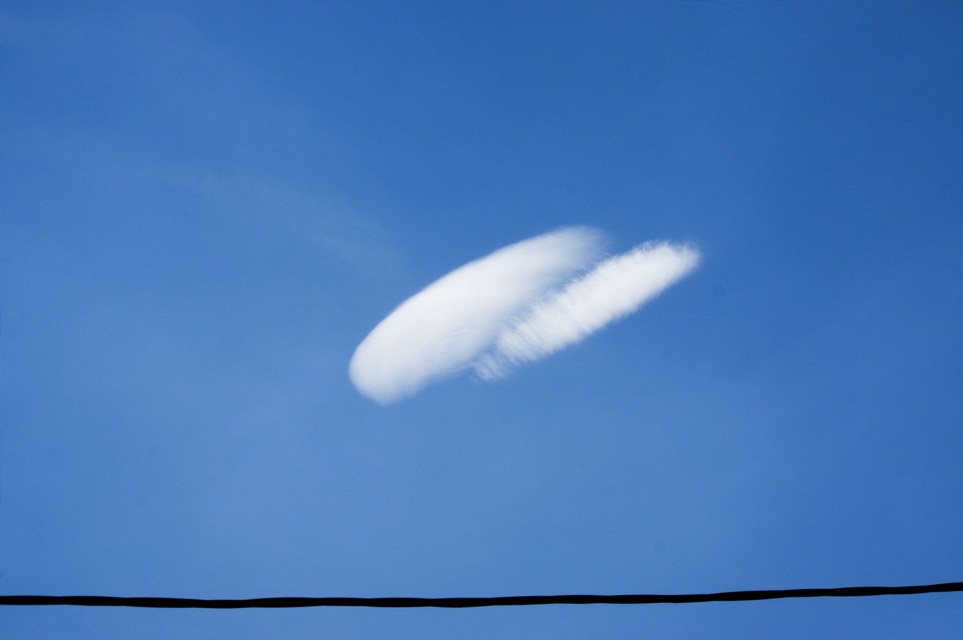 Lone cloud in a vast blue sky with minimal obstruction. Perfect for backgrounds.