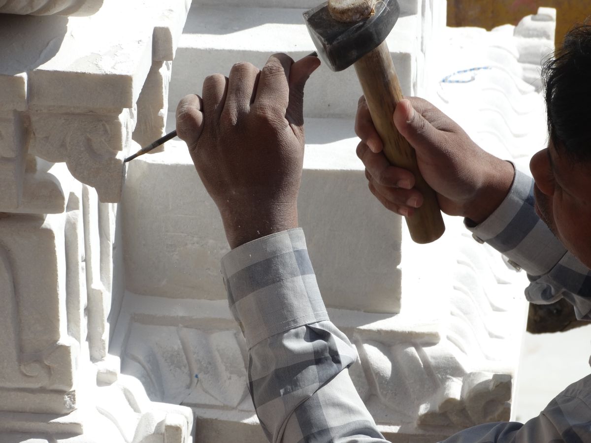 Craftsperson forming a detailed stone feature