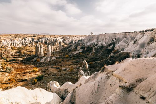 Free Picturesque scenery of fairy chimney rocky formations located in Goreme National Park against cloudy sky in Cappadocia Stock Photo