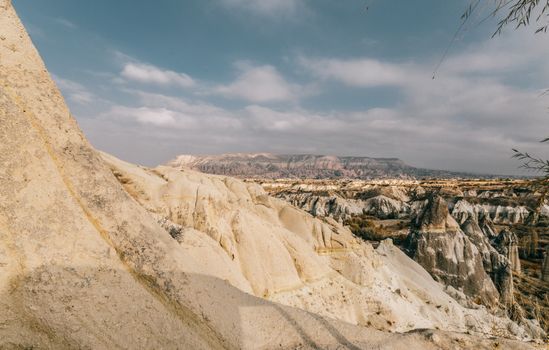 Steep slope of sandstone mountain located in Goreme National Park with various rocky formations in Cappadocia