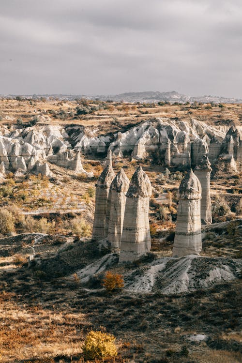 Free Rocky formations in valley in Cappadocia with grass and hills Stock Photo