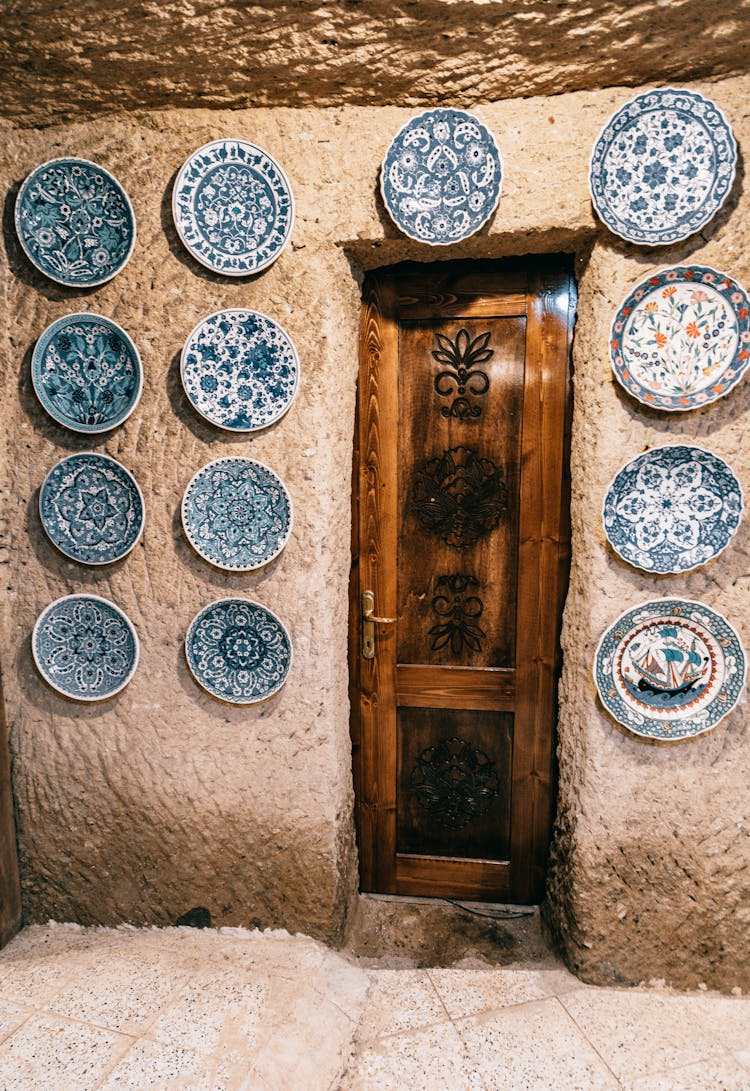 Entrance Of Aged Stone Building With Wooden Door And Plates