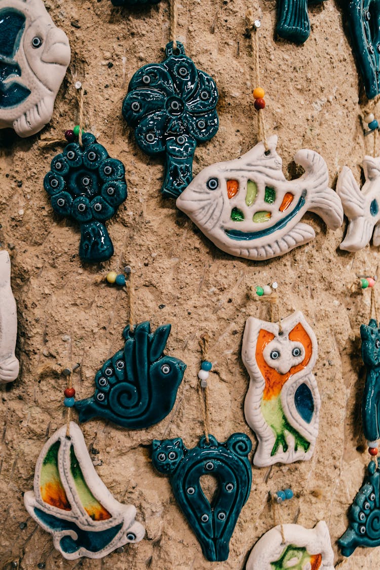 Different Amulets With Birds And Fish On Stone Wall