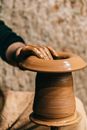 Person doing clay modeling on pottery wheel