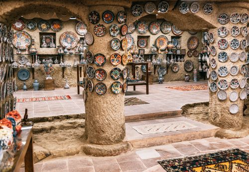 Free Moroccan plates hanging on rough stone walls and columns in building with carpets on floor Stock Photo