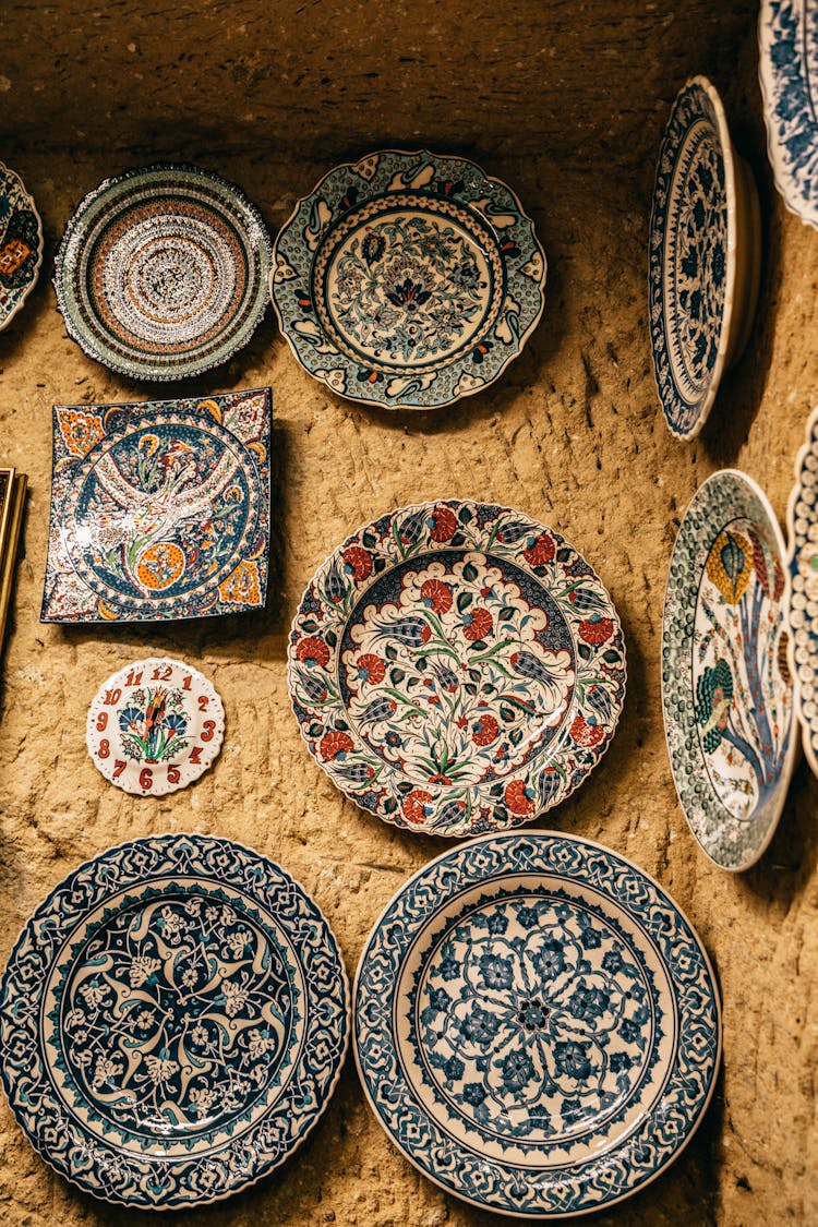 Bright Decorative Ceramic Plates With Ornaments On Stone Wall