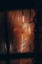 Raindrops flowing through misted glass window in evening