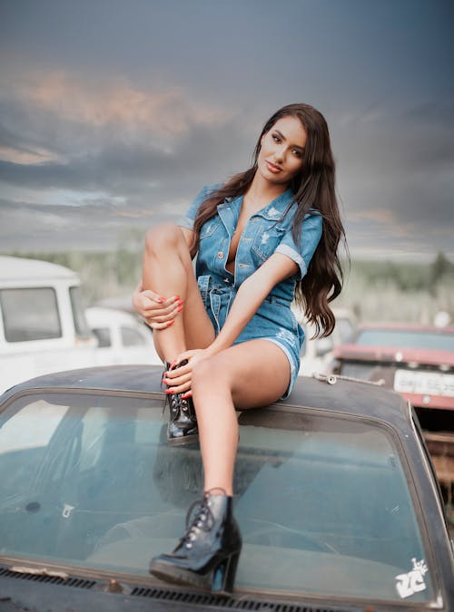 Free A Woman Sitting on Top of a Car Stock Photo