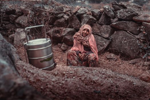 Woman Sitting with Keg among Rocks