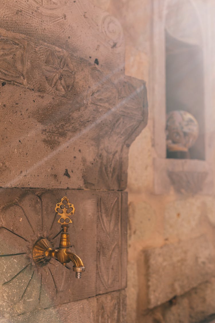 Golden Faucet On Shabby Wall