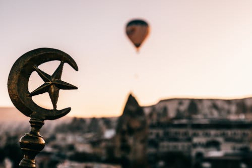 Soft focus of Turkey symbols on top of building against floating air balloon under Cappadocia terrain at dawn