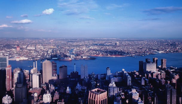 Stunning aerial view of New York City skyline with Hudson River and clear skies.