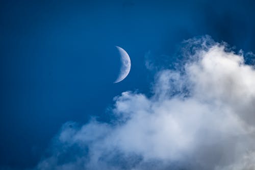 Free Photograph of a Crescent Moon Above White Clouds Stock Photo
