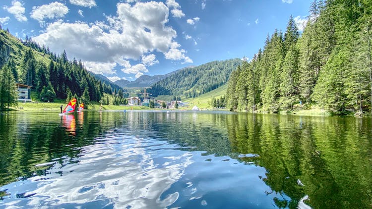 Photo Of People Windsurfing On A Lake