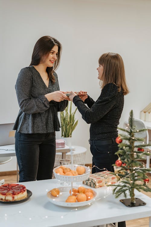 Photo of a Woman Giving a Present to Another Woman