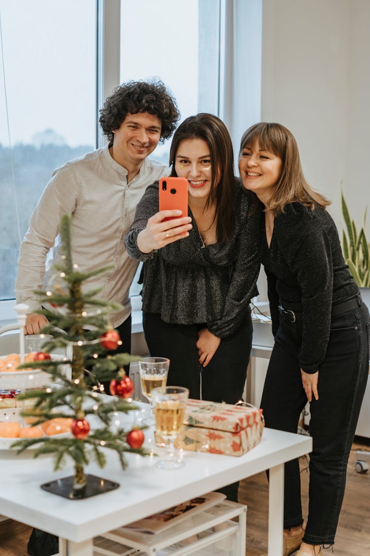 A Group Of Friends Taking A Picture With A Cell Phone