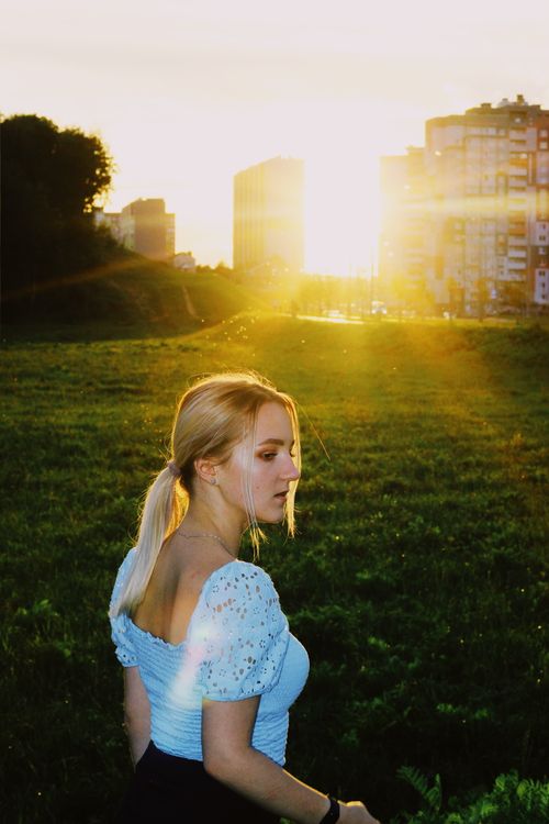Free A young woman enjoys a serene sunset in an urban park in Minsk, capturing golden hour magic. Stock Photo