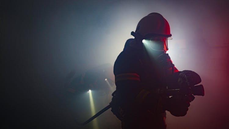 Photo Of A Firefighter Holding A Hose