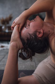 A young woman practices yoga indoors, demonstrating flexibility and focus.