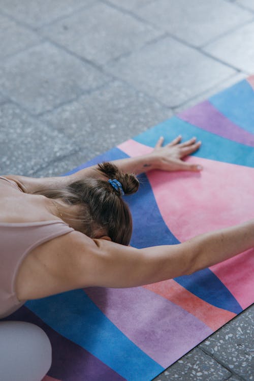 Photo of a Woman Doing Yoga on a Colorful Yoga Mat