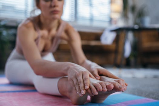 Adult woman stretching during a yoga session indoors, focusing on healthy living.