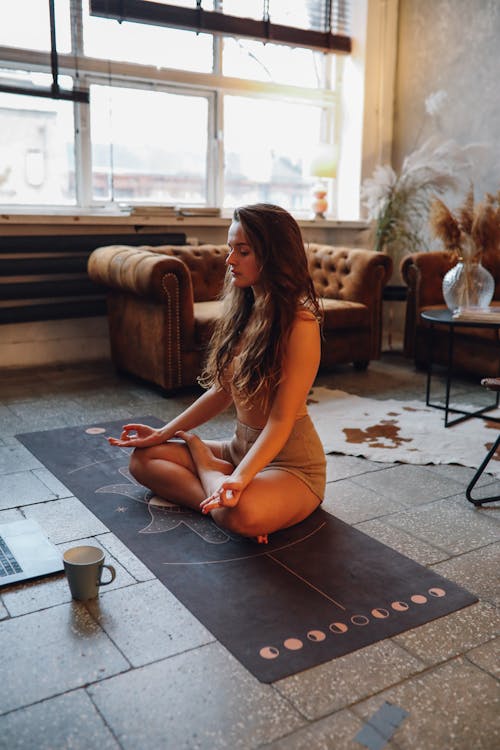 Free Woman in Orange Tank Top Sitting on Black Table Stock Photo