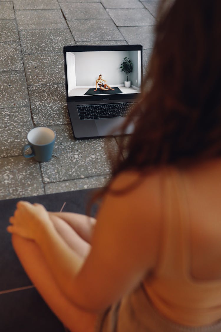 Woman Watching Yoga Exercise On A Laptop 