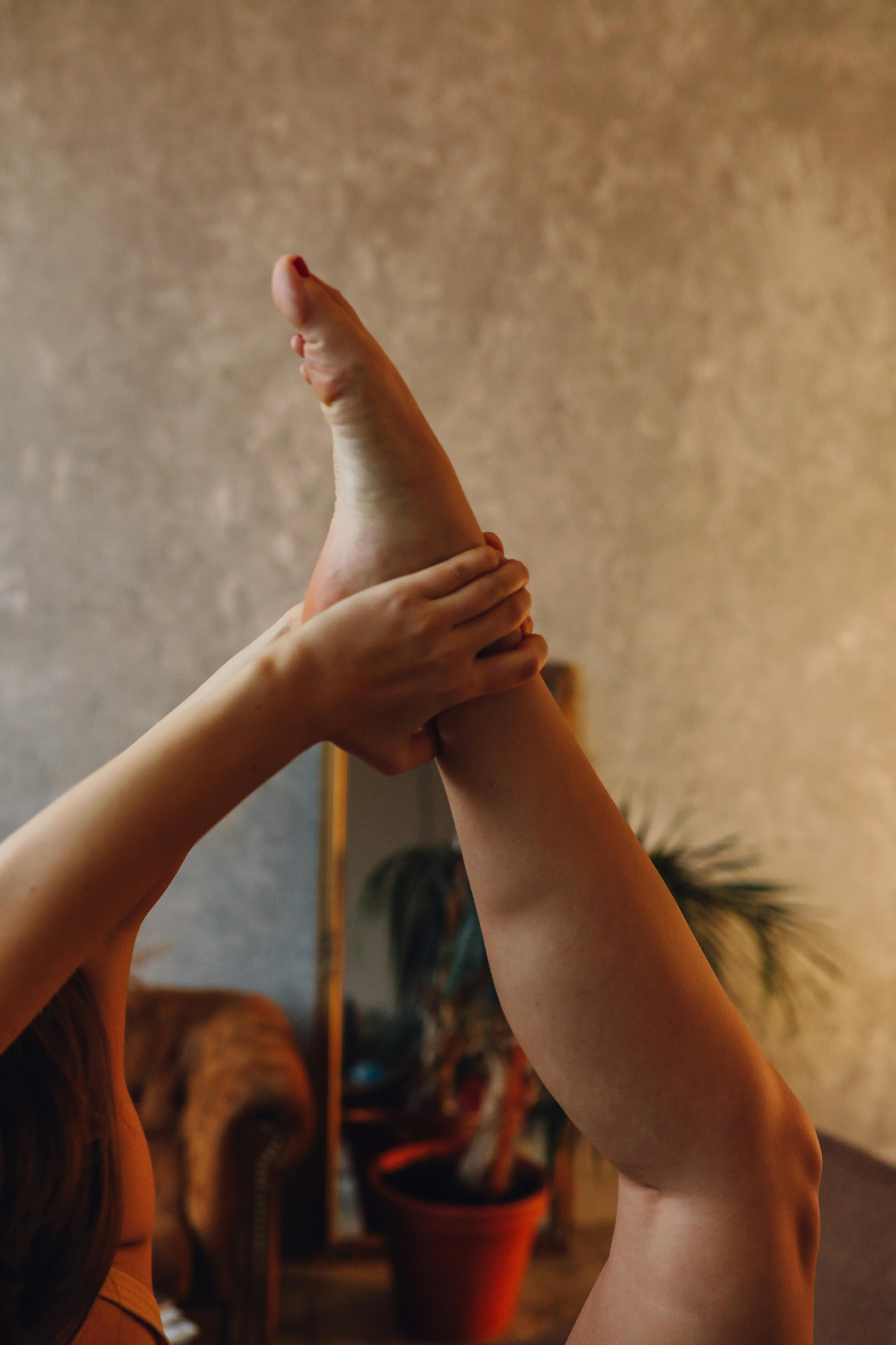 A woman performing a yoga stretch indoors, showcasing flexibility and healthy living.