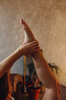 A woman performing a yoga stretch indoors, showcasing flexibility and healthy living.