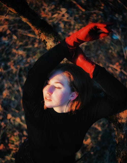 Model Posing in Black Sweater and Red Gloves