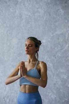 A woman in active wear practicing yoga indoors, promoting mindfulness and inner peace.