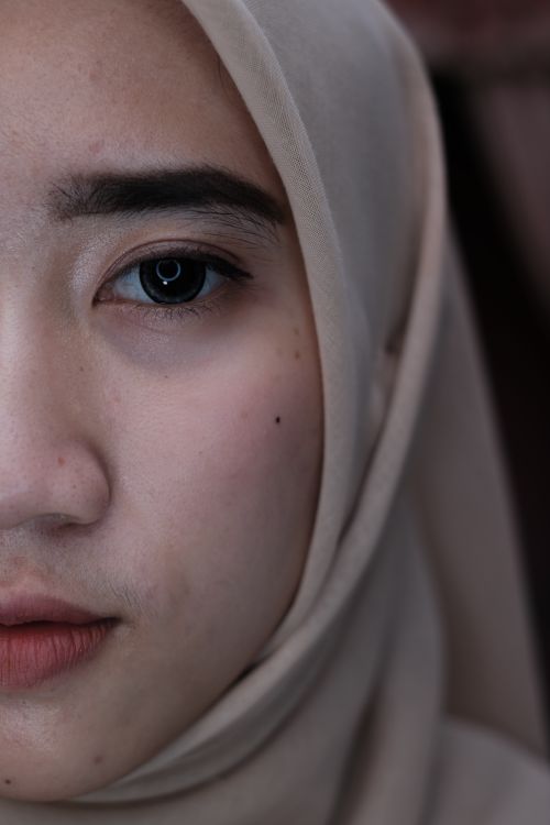 Free Headshot of calm local ethnic female wearing traditional beige headdress looking at camera while standing in room on blurred background Stock Photo