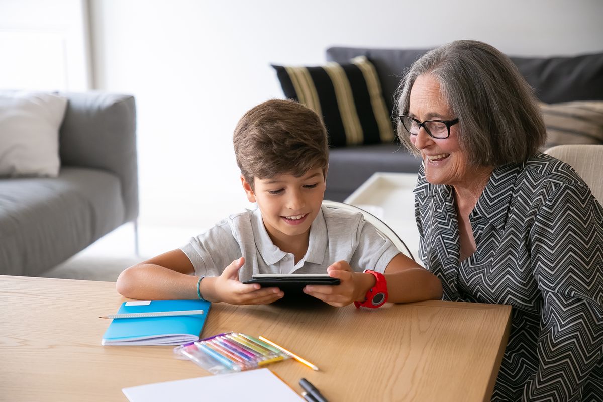 A grandmother and child looking at a phone together in a calm home setting