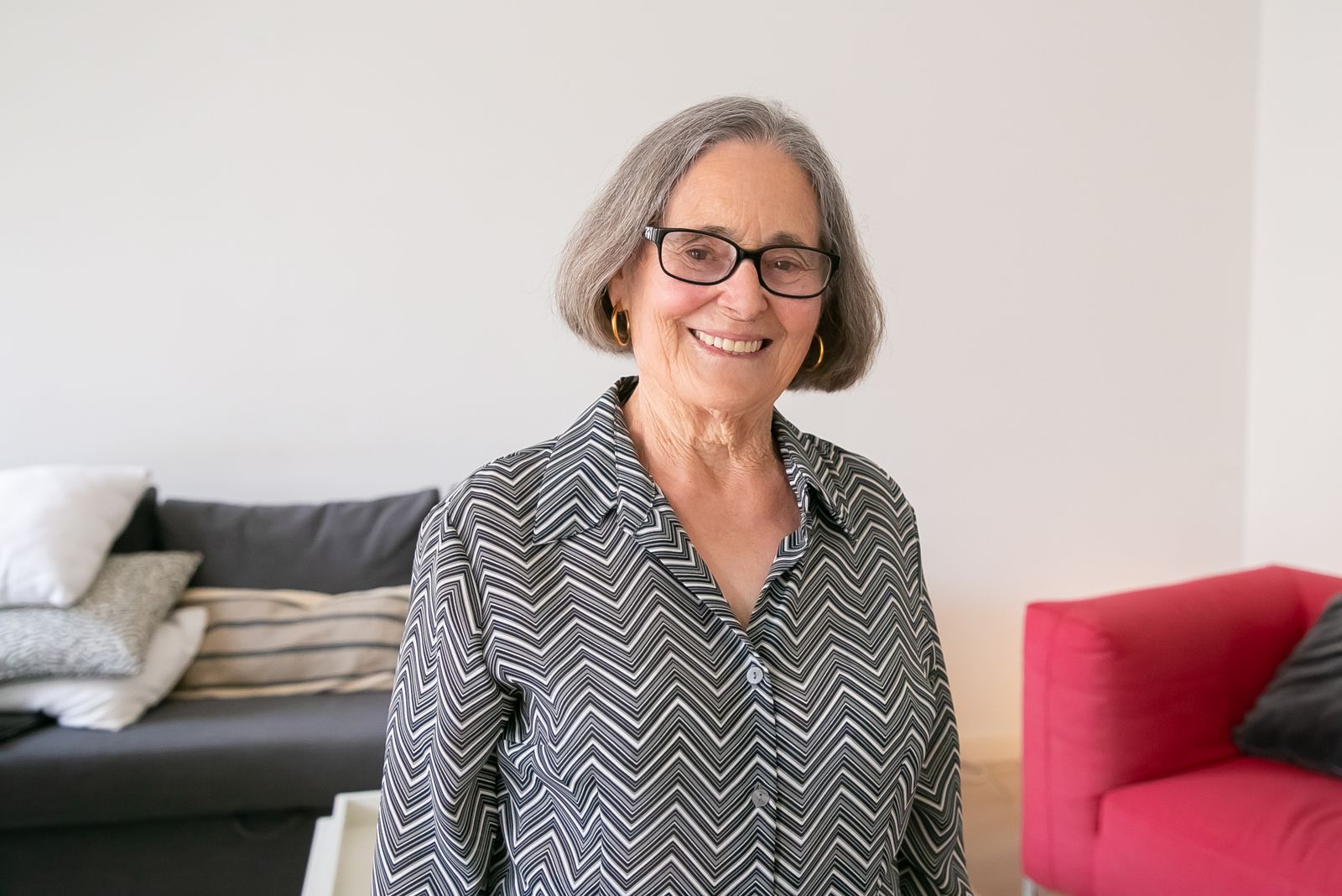 Portrait d'une femme âgée souriante dans son salon