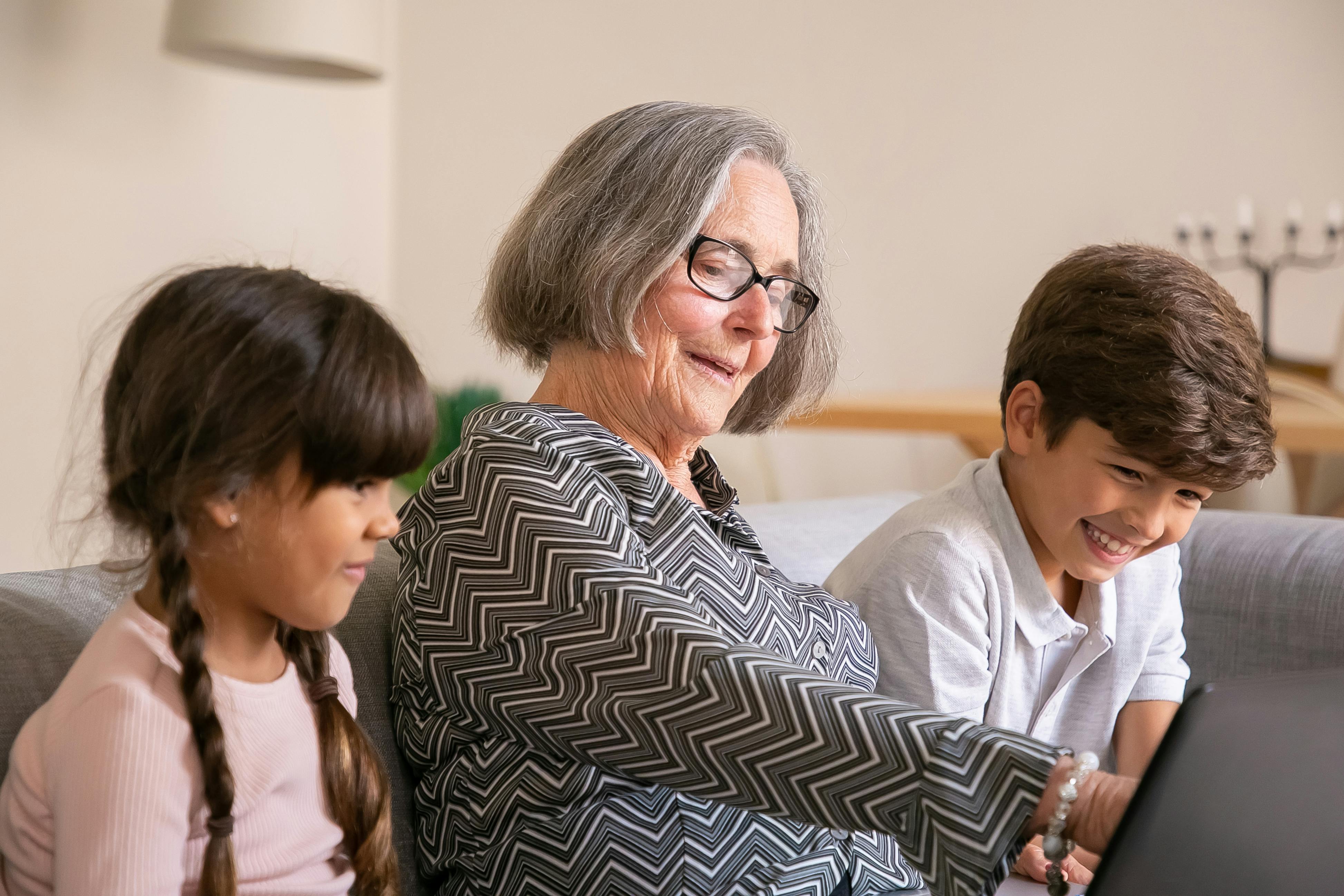 Smiling grandmother with grandchildren on the couch