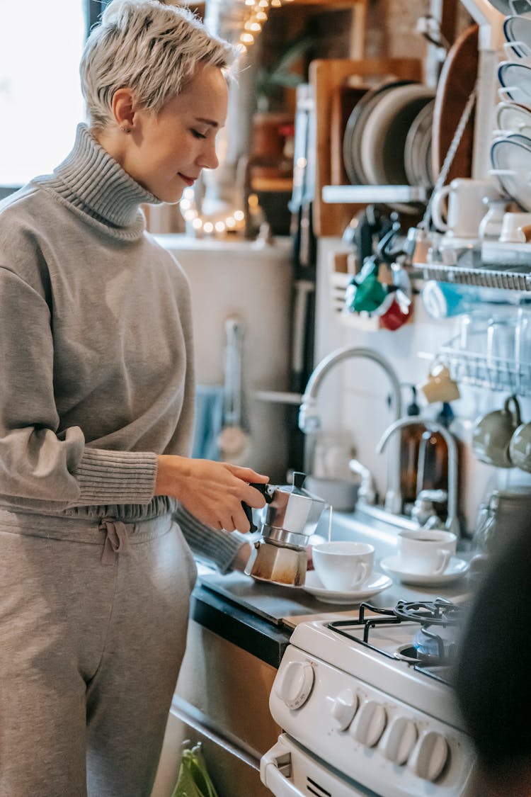 Woman Preparing Coffee In Kitchen At Home