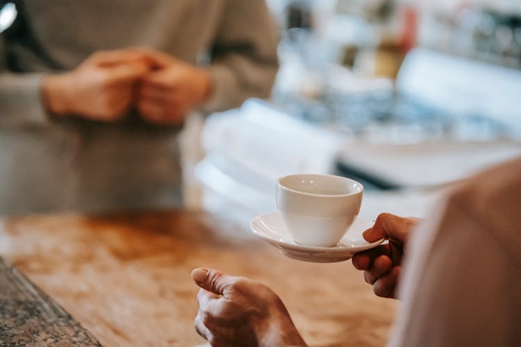 Anonymous Couple Drinking Coffee In Kitchen