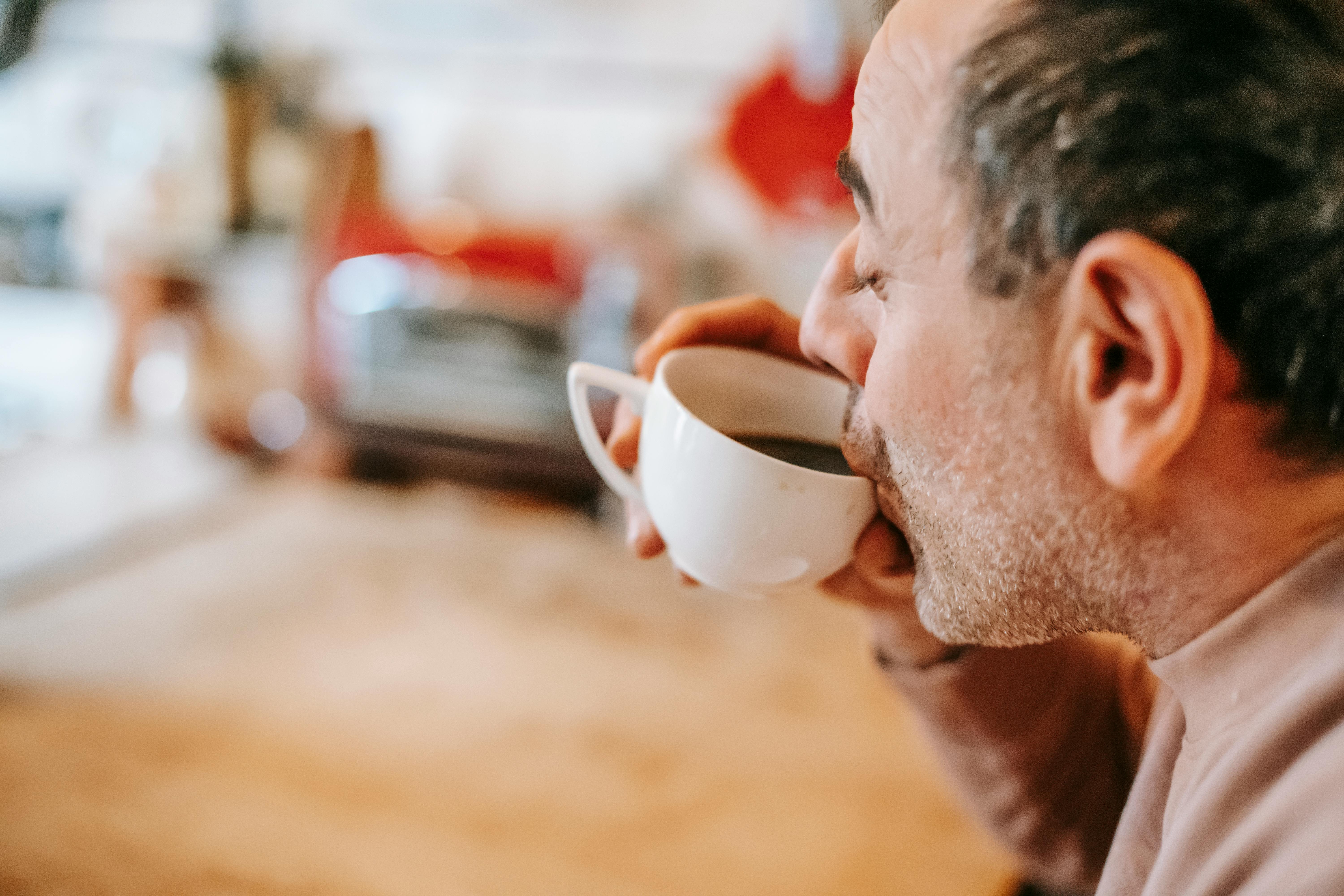 content ethnic man drinking coffee at home