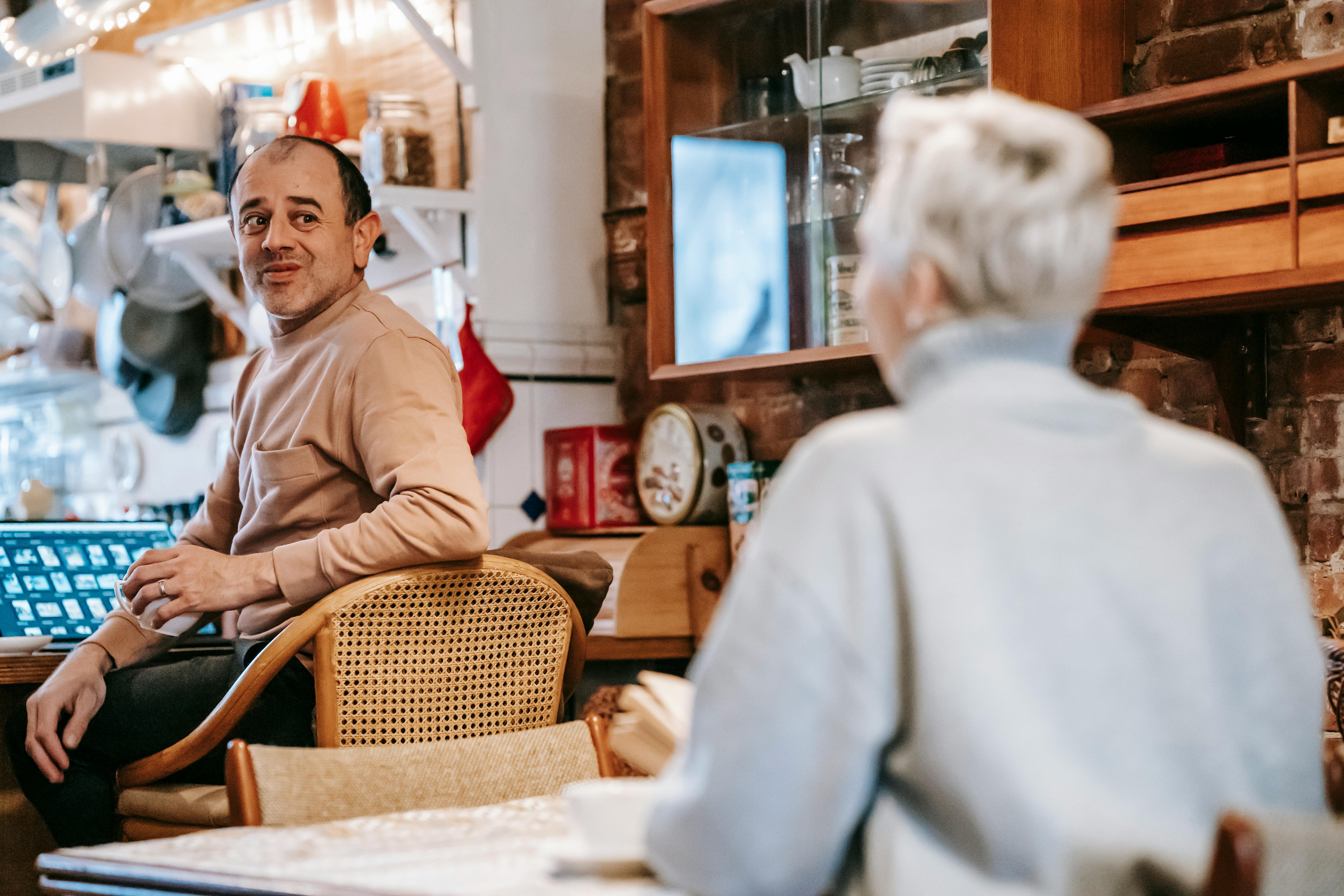 positive middle aged diverse spouses communicating during breakfast at home