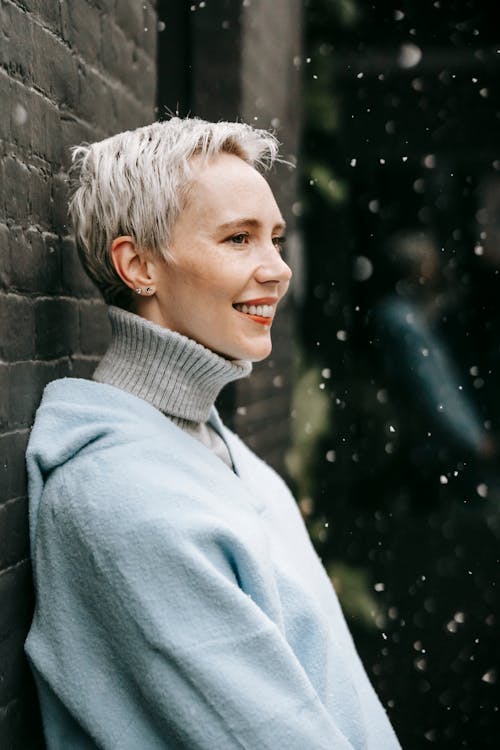 Smiling woman with short hair in warm clothes outdoors