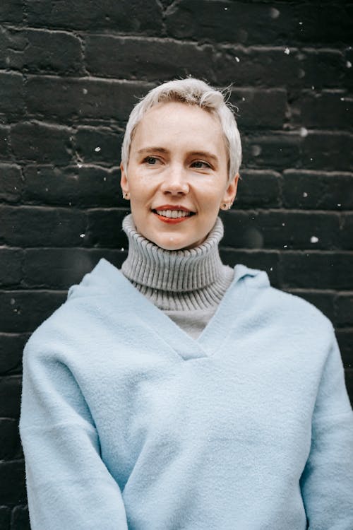 Dreamy woman in warm clothes on brown background