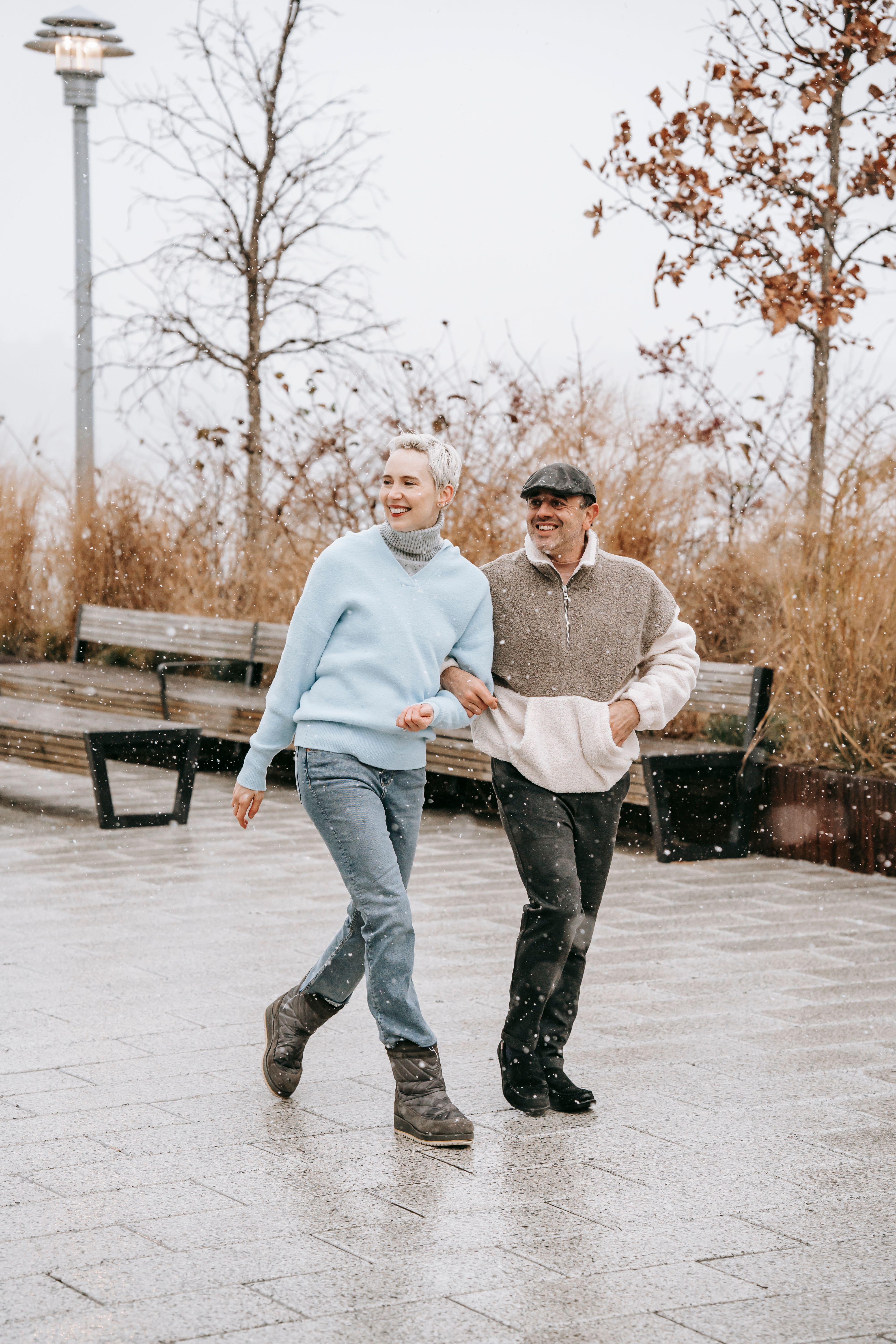 Happy couple walking on urban pavement in autumn · Free Stock Photo