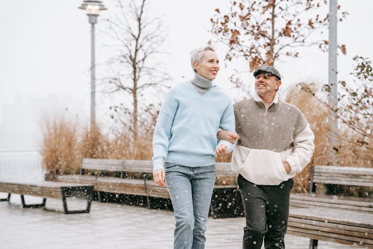 Smiling Couple Walking On Pavement In Autumn City