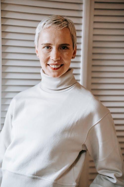 Positive woman with short hair smiling and looking at camera