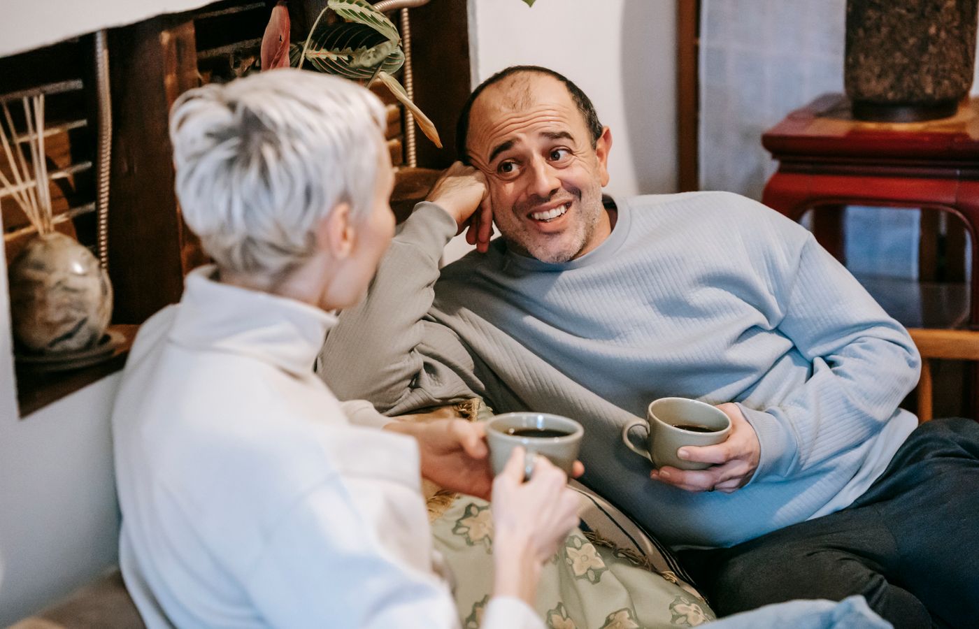Two friends enjoying a casual coffee chat indoors, creating a warm atmosphere.